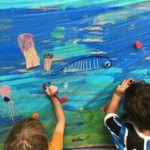 Niños pintando mural del mar